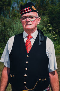 Portrait of man standing against tree