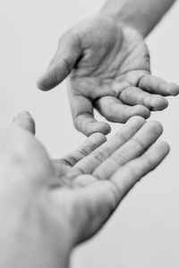 Close-up of man holding hands over white background