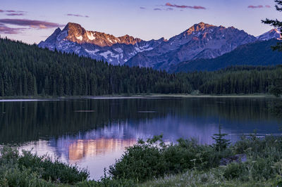 Scenic view of lake by mountains against sky