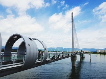 View of bridge over river against cloudy sky