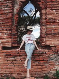 Low section of person standing against brick wall