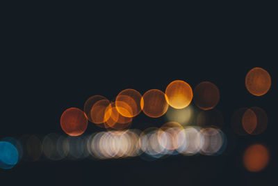 Low angle view of illuminated lights against clear sky at night