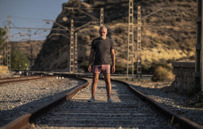 Full length of man standing on railroad track