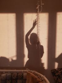 Shadow of woman standing against wall at home