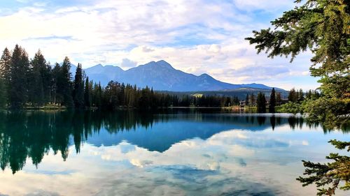 Scenic view of lake by trees against sky