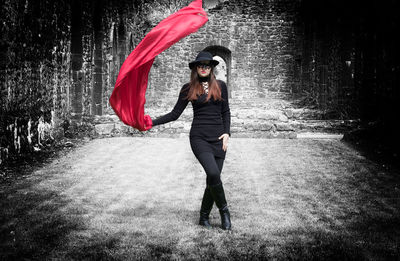 Full length portrait of young woman standing outdoors