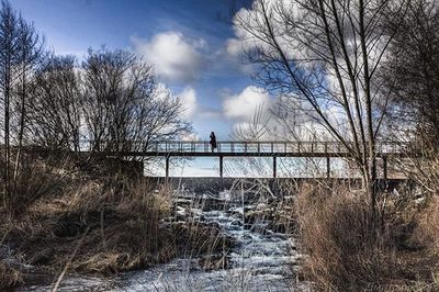 Scenic view of river against cloudy sky