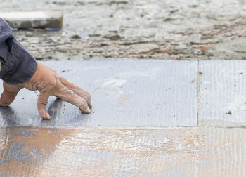 Cropped hand of man with tiles on floor