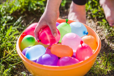 Midsection of person holding multi colored candies