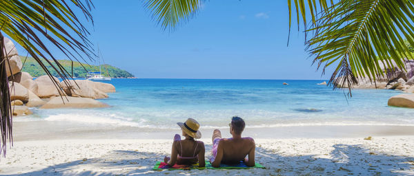 Rear view of woman sitting on beach