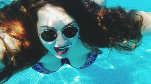 Beautiful woman swimming in blue pool