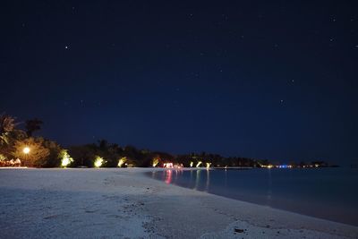 Scenic view of snowy field against clear sky at night