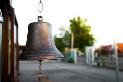 Close-up of lamp hanging on wall by street