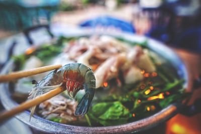 Close-up of chopsticks holding seafood