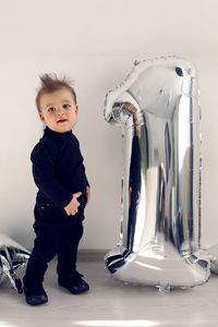 Baby boy in black clothes one year with silver inflatable figure