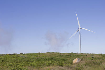 Windmill on field against sky