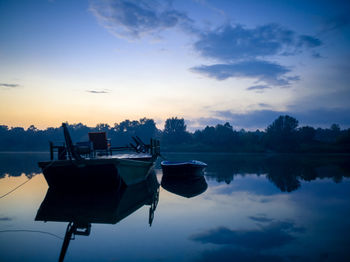 Boat moored in sava river against sky during sunset