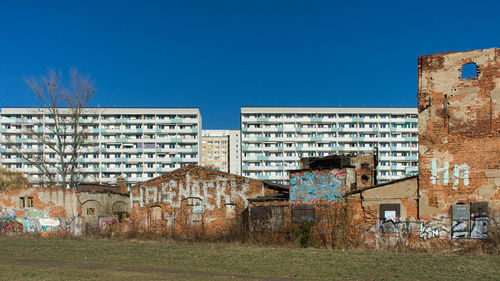 Graffiti on old building against clear blue sky