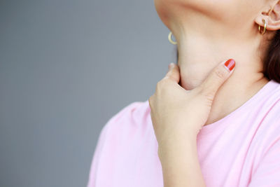 Close-up of young woman against gray background