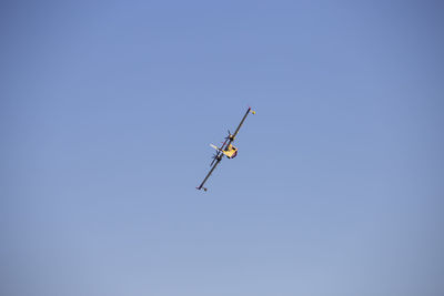 Low angle view of airplane against clear blue sky