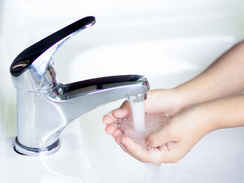 Midsection of person pouring water in glass