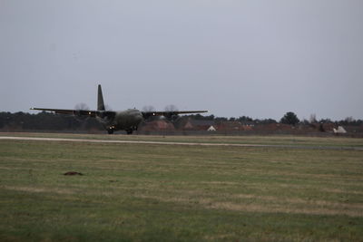 Airplane on field against sky