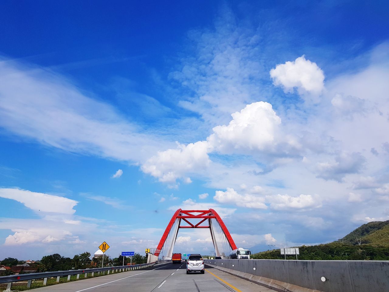 VIEW OF BRIDGE IN CITY AGAINST BLUE SKY
