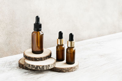 Glass dropper bottles for healthy skincare on wooden cut. spa concept