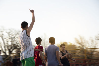 Friends playing street basketball