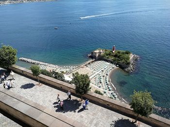 High angle view of people walking by sea