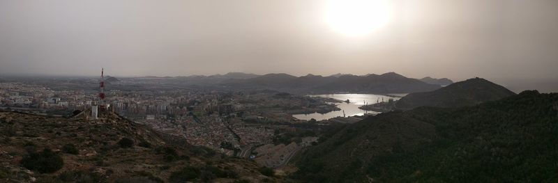 Panoramic shot of mountains and city against sky