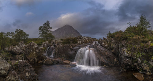 Scenic view of waterfall before buachaille etive mor