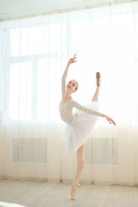 Full length of young woman doing yoga at home