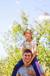 Portrait of young woman sitting on tree