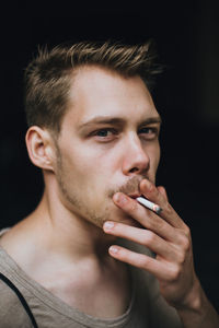 Young man smoking cigarette outdoors