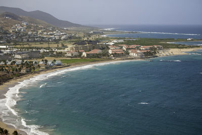 High angle view of townscape by sea against sky