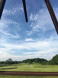 Scenic view of grassy field against cloudy sky