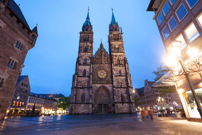 View of illuminated buildings in city against sky