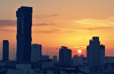 Buildings against cloudy sky at sunset