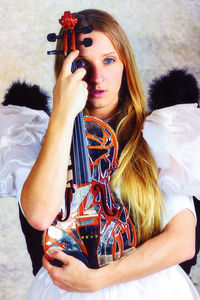 Portrait of beautiful young woman playing guitar at music concert