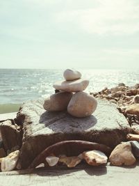 Close-up of pebbles on beach against sky