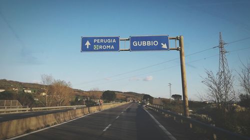 Road sign against blue sky