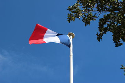 Low angle view of flag against clear blue sky