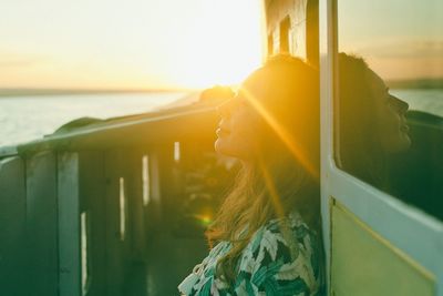 Portrait of woman looking at sea shore against sky