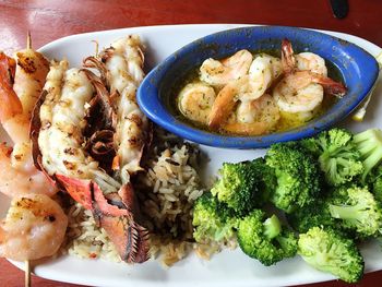 High angle view of lobsters with shrimps and broccoli in plate on table