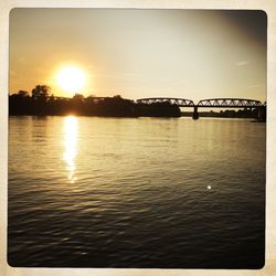 Bridge over river at sunset