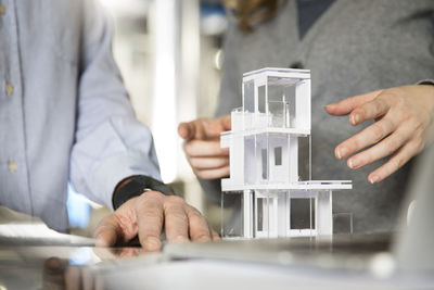 Close-up of colleagues with architectural model