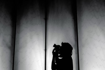 Portrait of a cat standing against wall