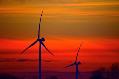 Scenic view of sunset with two windmills