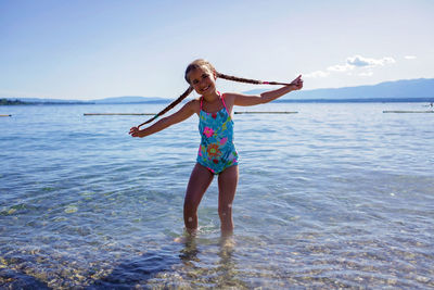 Girl has fun on pebble beach on geneva lake, fun, happiness, summer vacations and travel